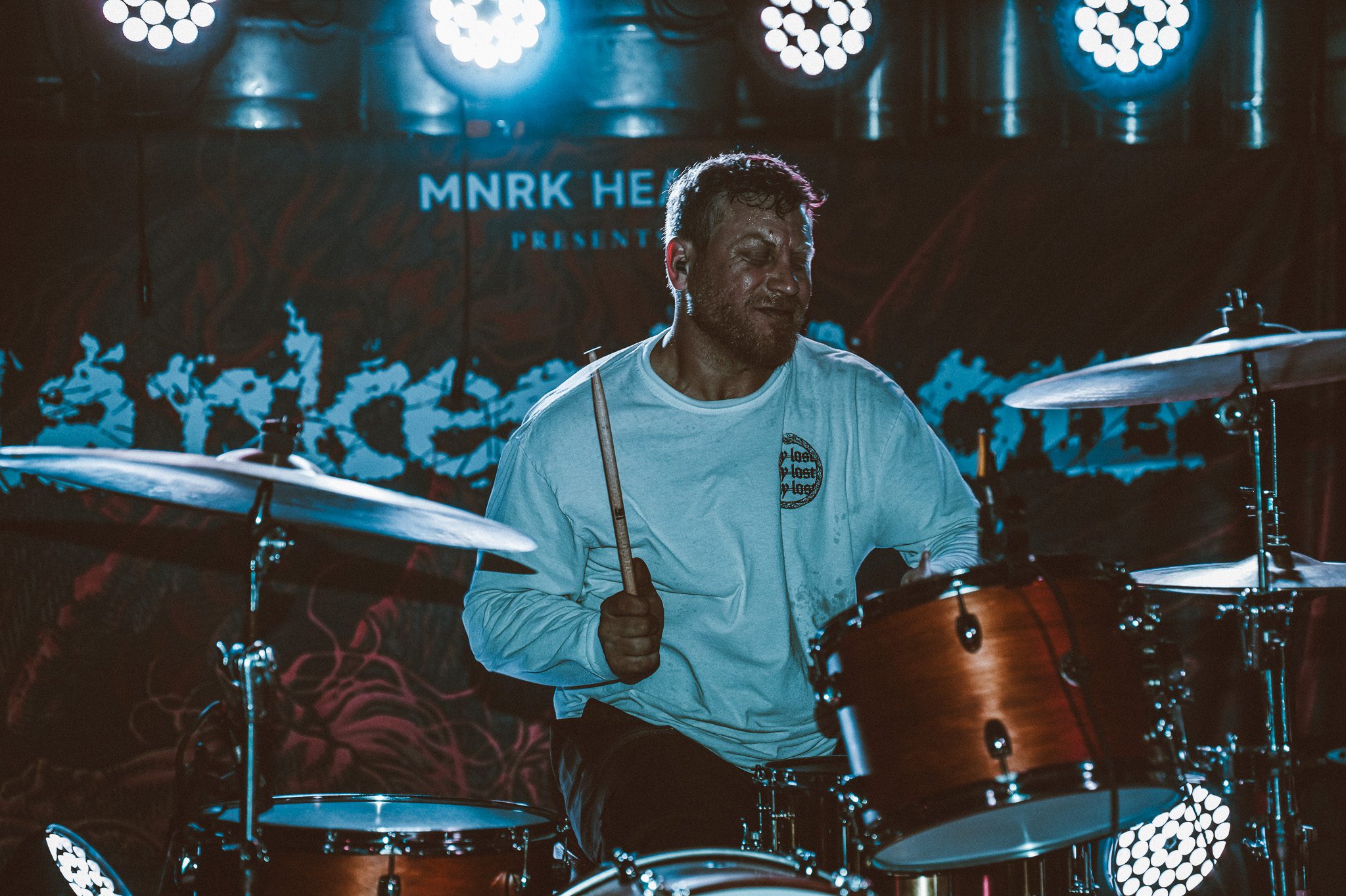 Aerial view of a lush green landscape with tropical trees and an orange canopy, situated near a beach with waves crashing onshore.