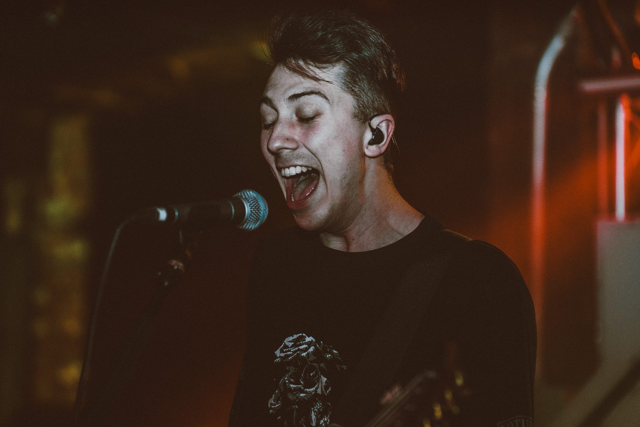 A metal band performing live on stage, with intense lighting and musicians actively engaging with the crowd.