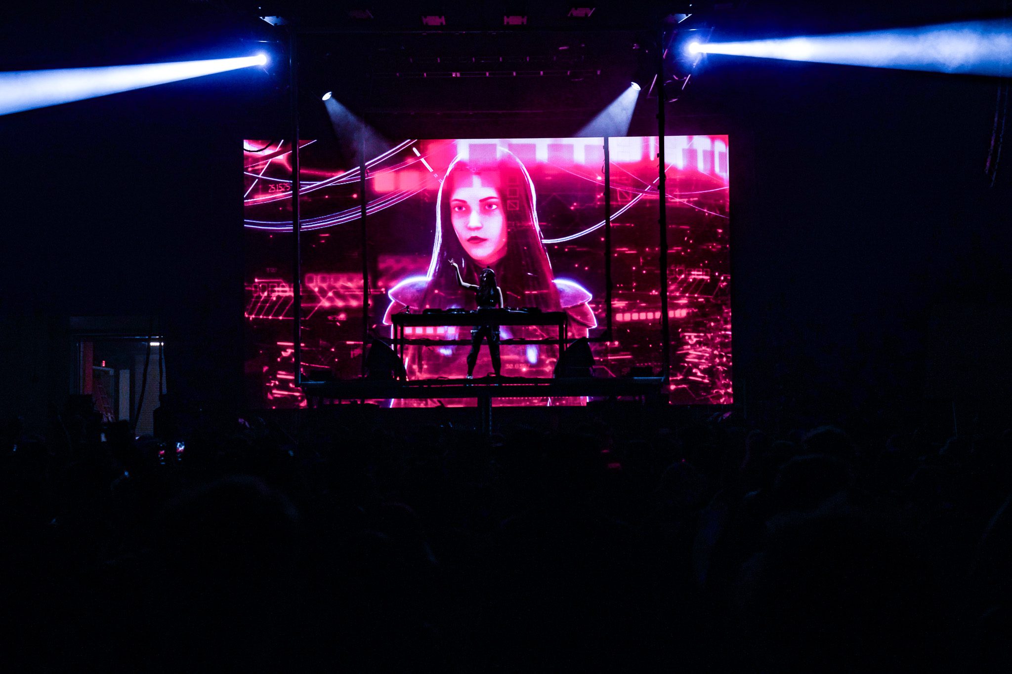 Drummer performing on stage with colorful lighting and holiday decorations in the background.