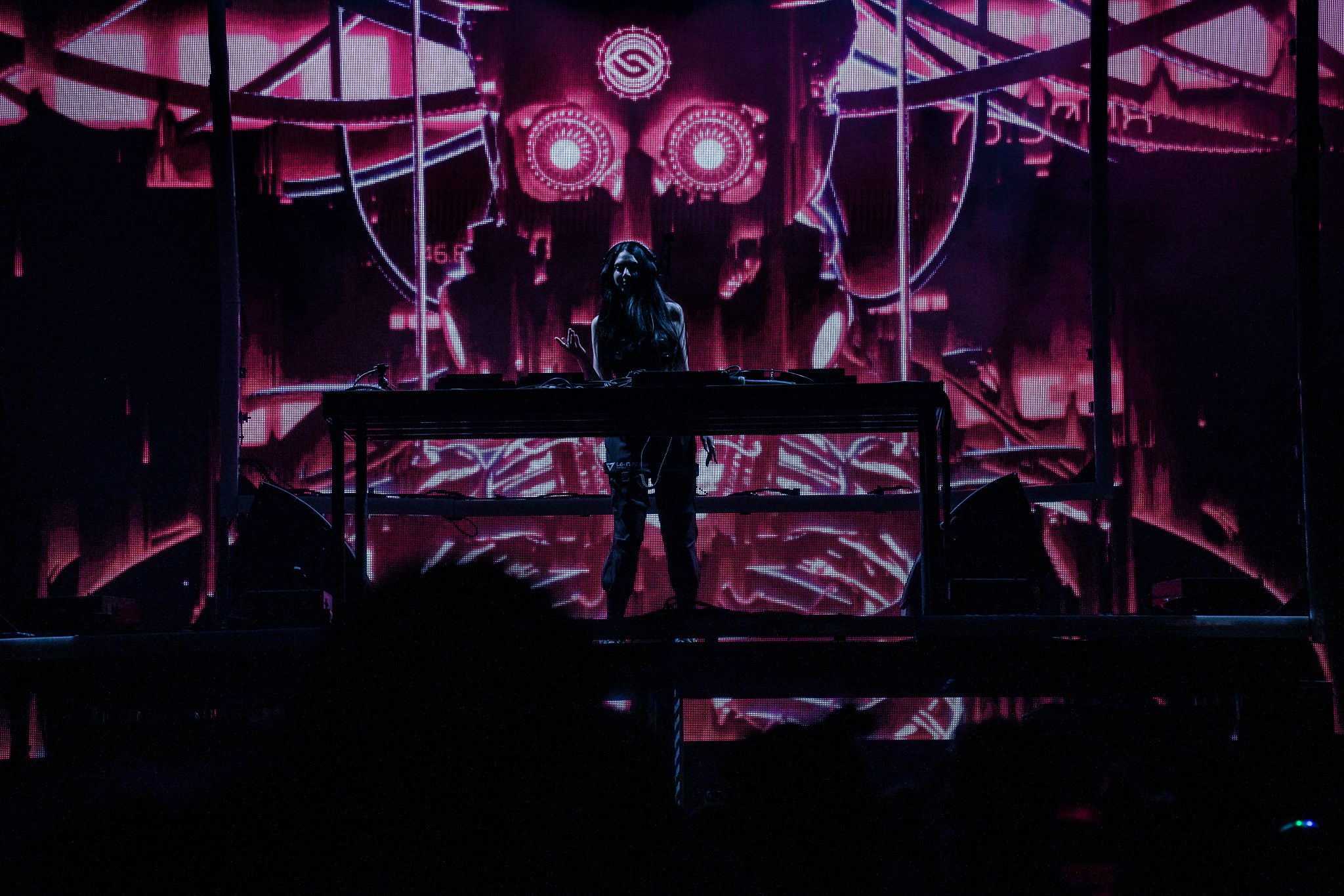 A musician passionately performing on stage with a guitar, illuminated by colorful lights, creating an energetic atmosphere.