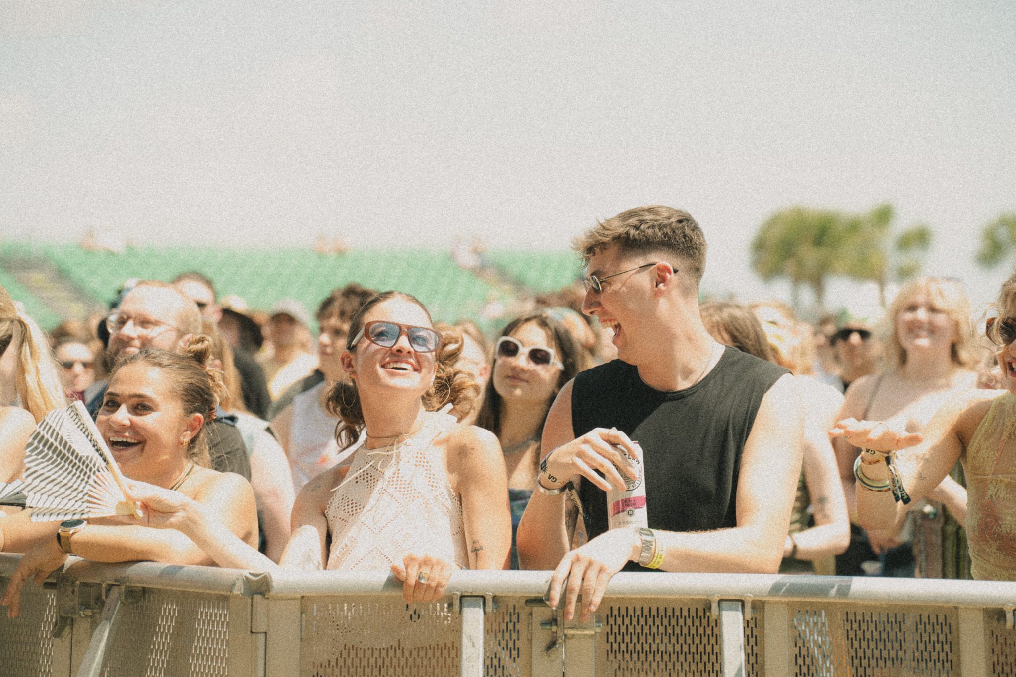 A lively crowd of festival attendees enjoying a performance at High Water Festival, with smiles and laughter evident as they share the experience.