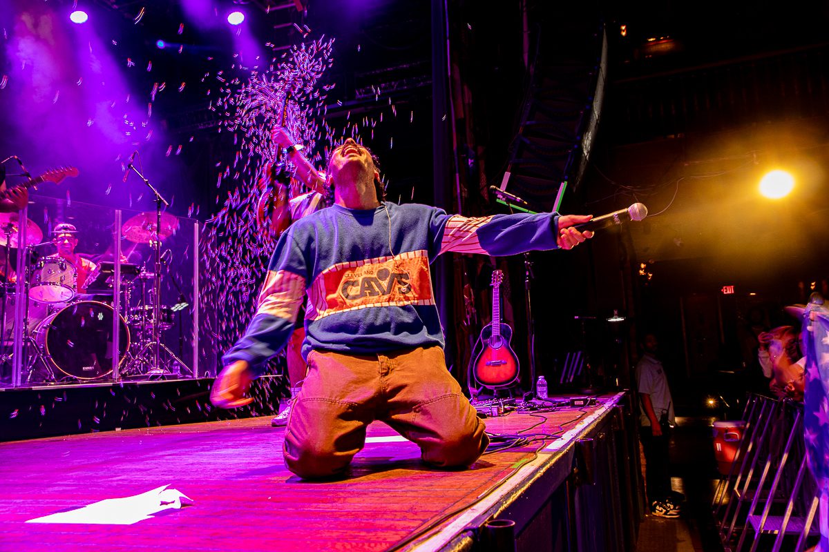 Anees performing on stage at the House of Blues in Cleveland, Ohio, with colorful stage lights and confetti falling around him.