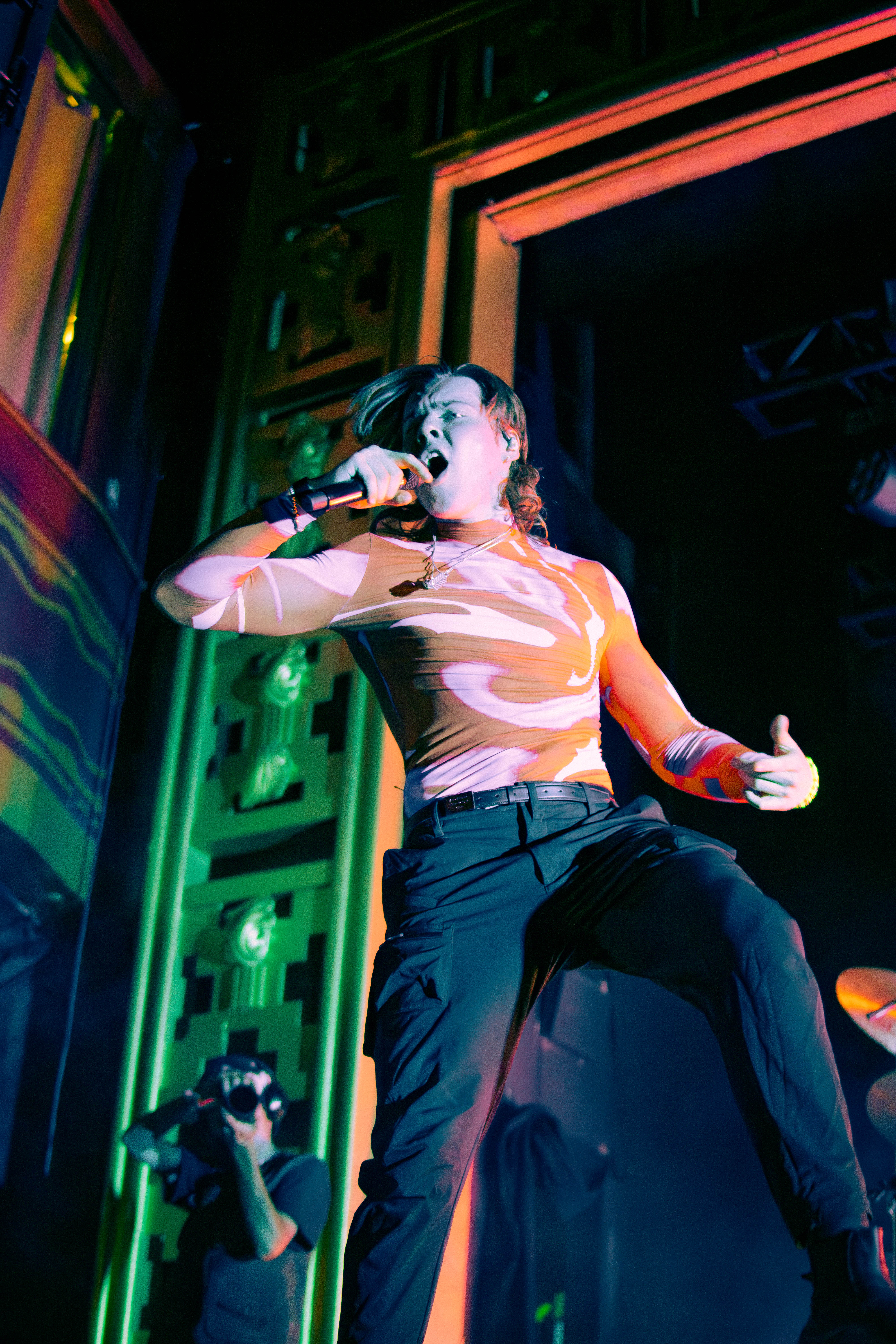 A lively performance by the singer-songwriter Livingston on stage, showcasing his energy and style, with vibrant lighting illuminating the scene.