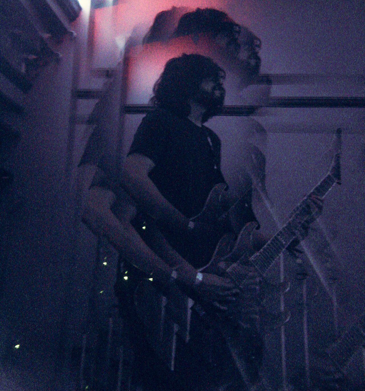 A guitarist from the band Dead Within Days performing on stage, captured with motion blur effects, showcasing a dynamic performance atmosphere.