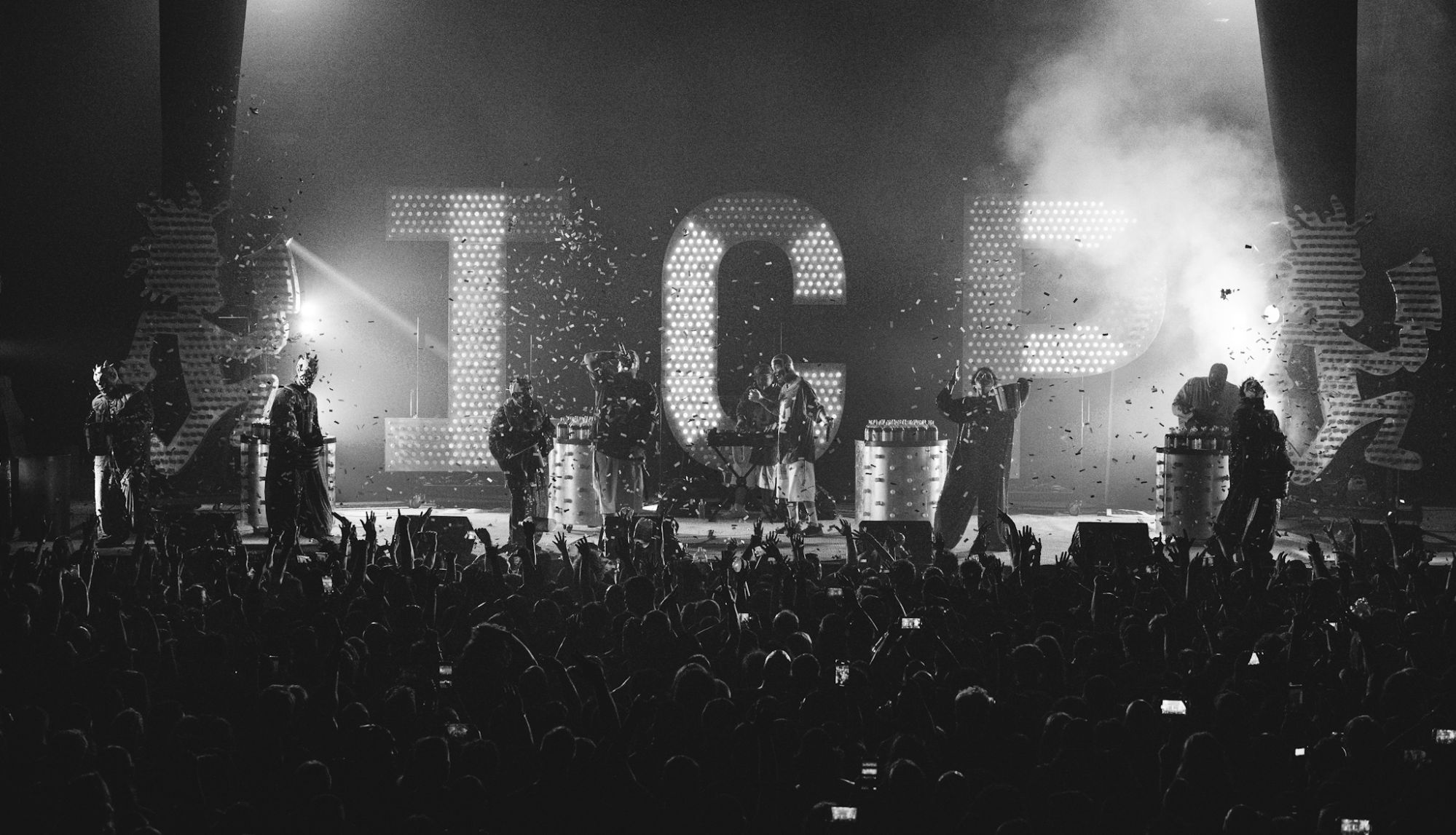 Insane Clown Posse performing on stage with large illuminated letters spelling 'ICP' in the background, surrounded by an enthusiastic crowd and confetti.