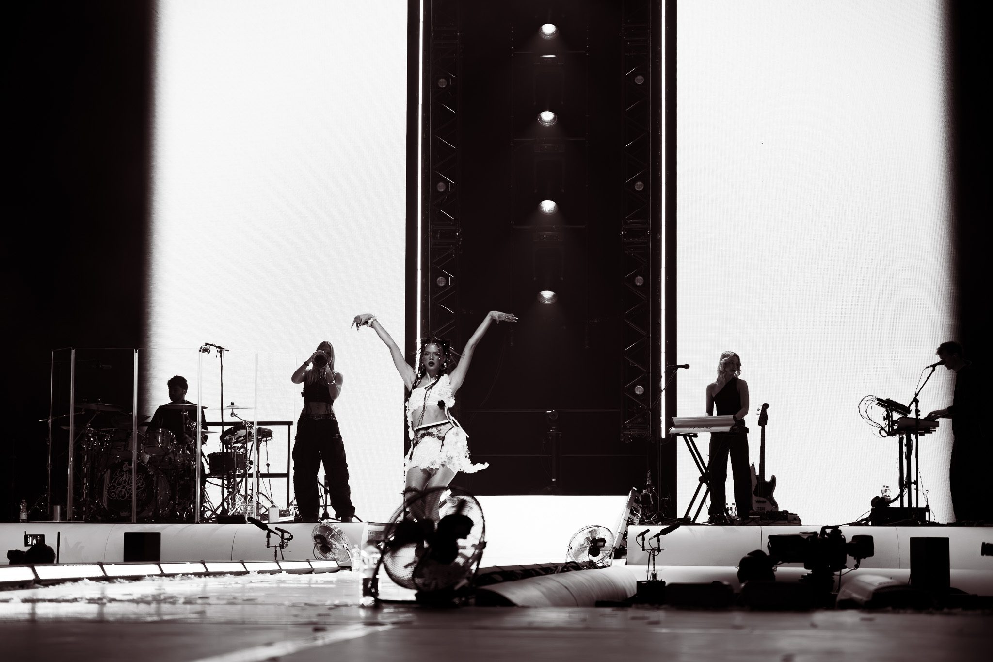 Nina Chuba performing on stage with her band at Olympia Hall, Munich, surrounded by dramatic lighting and fans enjoying the concert.