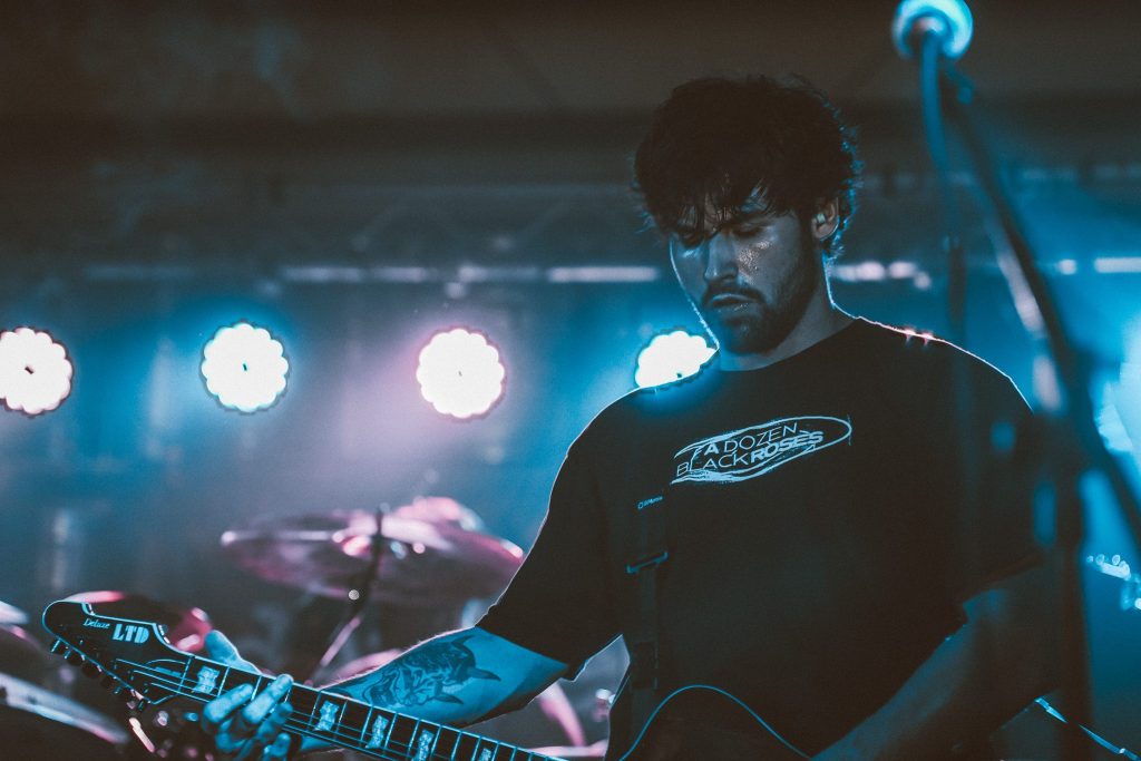 A nighttime street scene illuminated by streetlights, featuring a long road with light trails from passing vehicles. The text "Late Night Nostalgia" is styled above the street, accompanied by the artist's name, "Jbryan," in a flowing font.